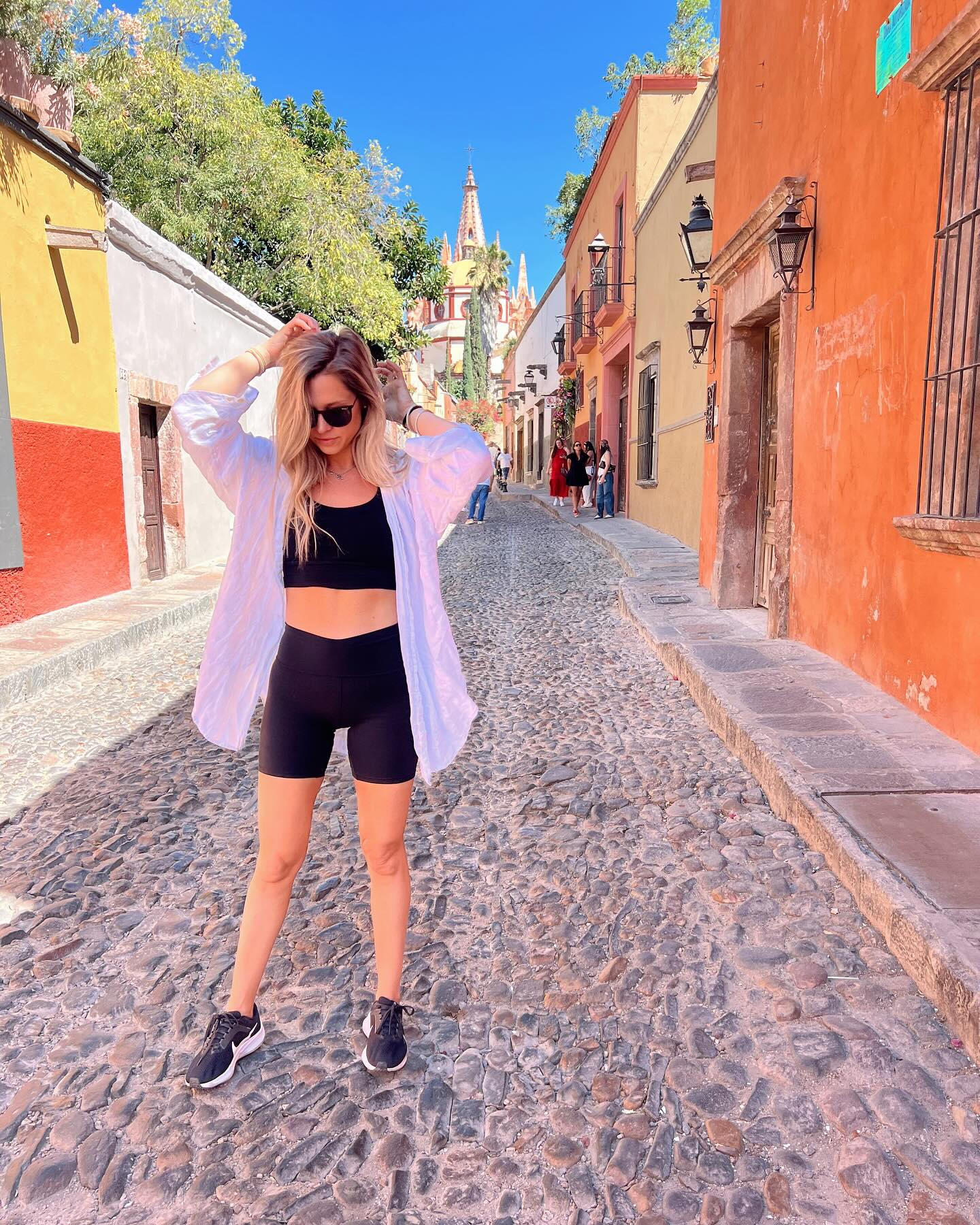 Andrea of Andie Pix on a sunlit cobblestone street